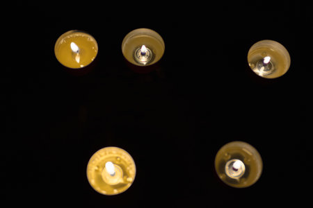 Warm candlelight glowing in the darkの写真素材