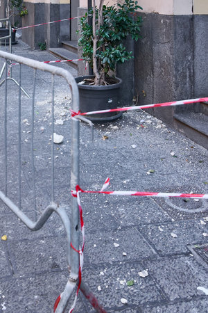 A facade collapse leaves debris spilled across a city sidewalk, marked with caution tape. Ideal for safety reports, urban planning articles and news coverage, it highlights the risks in urban areas.の写真素材
