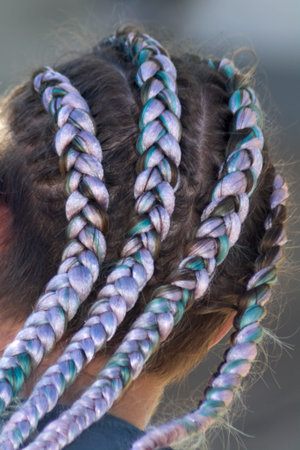A close-up of braided hair featuring vibrant colors and intricate design, showcasing modern...