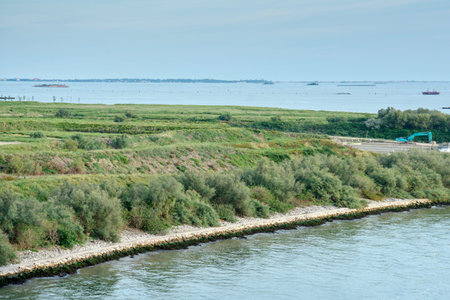 A view of the engineered shoreline of an island in the Venetian Lagoon, with rock reinforcements,...