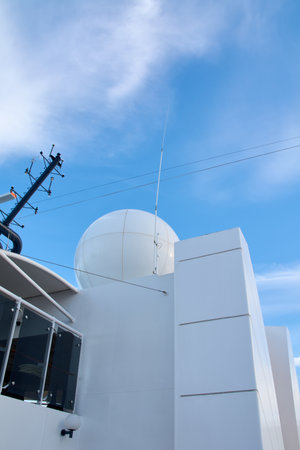 Low-angle view of satellite domes and antennas on a cruise ship. Modern technology ensures global communication and navigation at sea.の写真素材