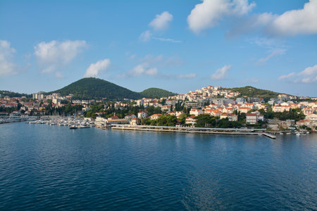 Panoramic view of Gruz harbor in Dubrovnik, Croatia, with boats and yachts in the marina and the city spreading over green hills under a blue sky.の写真素材
