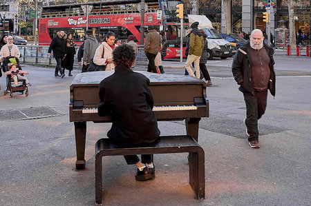 Barcelona. Spain - January 10, 2026: Everyday urban scene featuring a piano musician and a red tourist bus driving through the busy central streets of barcelona.のeditorial素材