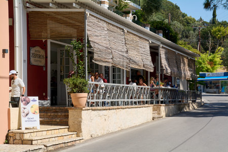 Corfu. Greece - January 22, 2026: Enjoy authentic Greek hospitality at the Zefiros Hotel outdoor cafe in Paleokastritsa, featuring traditional bamboo shades and Corfiot charm.のeditorial素材