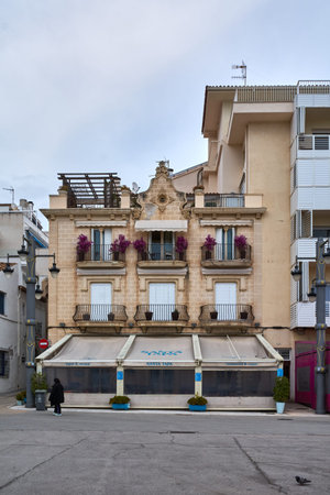 Sitges. Spain - February 17, 2026: Street level hospitality venue with visible signage and residential balconies above in urban seaside setting.のeditorial素材