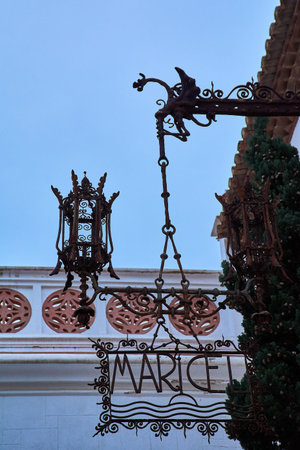 Sitges. Spain - February 18, 2026: Ornate wrought iron sign reading Maricel with decorative lanterns at Palau de Maricel in historic coastal quarter of Sitges.のeditorial素材