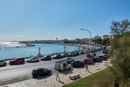 Bari, Italy - May 28, 2026: Mediterranean urban coastline featuring a seaside avenue with traffic, pedestrian promenade, historic city architecture in the background, and bright summer day light.