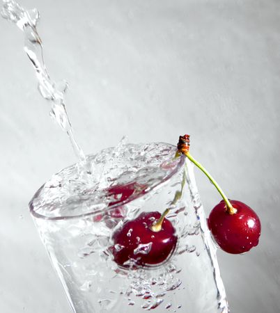 cherry under running water in a glass beakerの写真素材