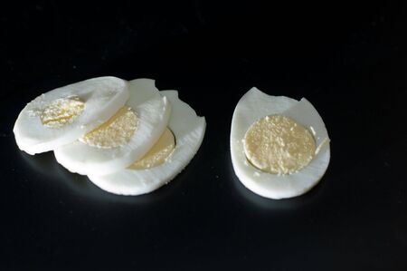close up of boiled sliced  egg on black backgroundの写真素材