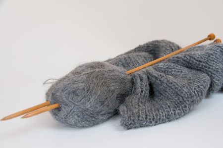 knitting piece in gray with wooden needles の写真素材