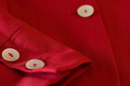detail of a red female business suit with a sleeve and  pearl buttonsの写真素材