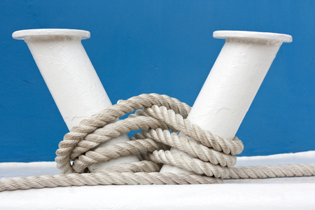 Hawser and white bollard on board of blue boatの写真素材