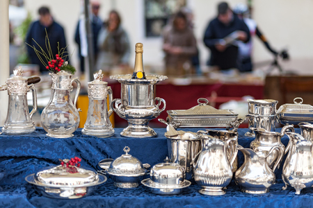 Champagne cooler and other silverware on flea market with people in the backgroundの写真素材
