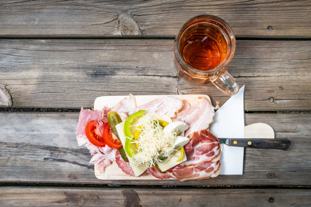 Brettljause, with meal, cheese, vegetable occupied bread traditional Styrian sandwich and a glass wine on wooden table in Austriaの写真素材