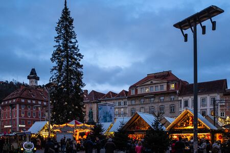 Christmas market Christkindlmarkt on main square in Graz with clocktower Uhrturm on hill Schlossberg, Styria, Austriaのeditorial素材