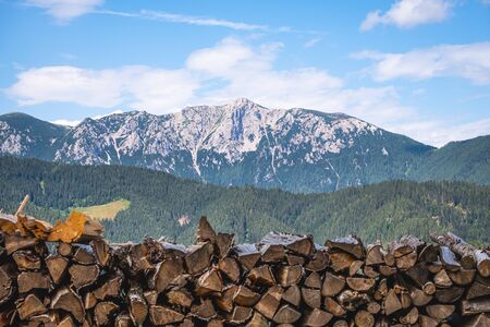 View over stacked wood pile to mountain Raduha in KamnikâSavinja Alps in northern Slovenia in summerの写真素材