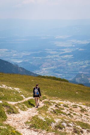 Hiking girl woman with view from mountain Hochobir to valley Jauntal in Carinthia, Austriaの写真素材