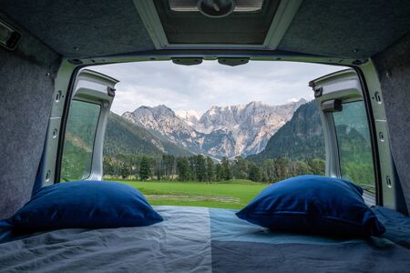 View from bed in camper van to green meadow in Zgornje Jezersko and Kamnik-Savinja Alps on a cloudy summer day in Sloveniaの写真素材