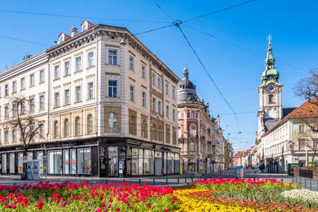 View from Eisernes Tor to street Herrengasse in deserted town Graz, Styria at virus quarantine on spring with beatifull flowers  and the old buildings, Austriaのeditorial素材