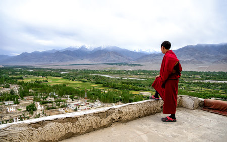 Thiksey, India - August 24, 2015: View of young monk on Thiksey gompa roof. Thiksey monastery is...