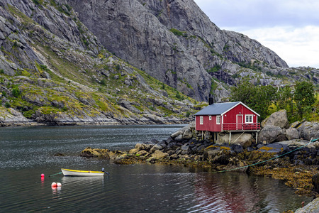 Traditional rorbu in Nusfjord settlement, Lofoten islands. Rorbu is type of house used by fishermen, built on land, but with the one end on poles in the water, allowing easy access to vesselsの写真素材