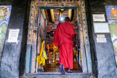 Thiksey, India - August 24, 2015: A buddhist monk entering in the prayer hall of Thiksey monastery for the Puja, a prayer ritual performed by hindus and buddhist for worship one or more deitiesのeditorial素材