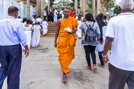 Anuradhapura, Sri Lanka - August 16, 2017: Buddhist monk brings a flower gift for Buddha at Ruwanwelisaya stupa in the ancient city of Anuradhapuraのeditorial素材