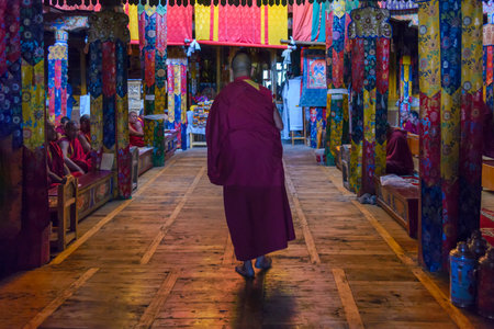 Samstanling Monastery, India - August 20, 2015: A monk enter in the prayer hall for morning puja. A puja is a prayer ritual performed by buddhist of devotional worship to one or more deitiesのeditorial素材