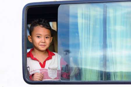 Phnom Penh, Cambodia - December 30, 2018: A cute little boy looking out of the window of his car in a street of Phnom Penh, the Cambodian capitalのeditorial素材