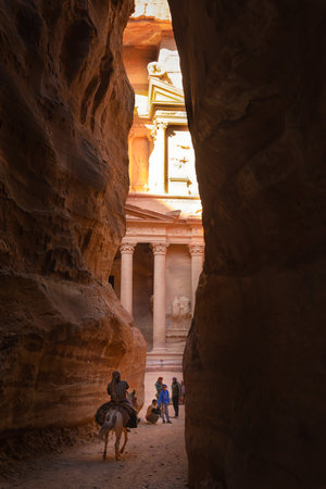 Petra, Jordan - April 06, 2015: Bedouin riding a mule at the end of the Siq, coming out in front of the Treasury, one of the most elaborate temples in Petra, a city of the Nabatean Kingdomのeditorial素材
