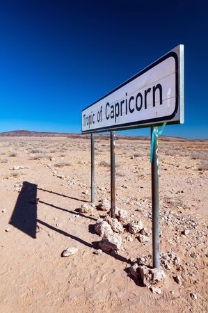 A sign marking the Tropic of Capricorn as it passes through Namibia desert. The Tropic of Capricorn is the circle of latitude that contains the subsolar point on the December solsticeの写真素材