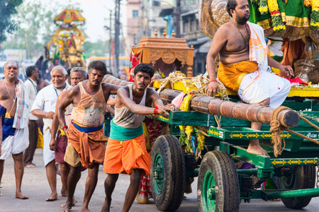 Madurai, India - August 23, 2018: Devotees pulling chariots with deities statues to Meenakshi Amman temple for the dormition ceremony. This Temple is dedicated to Meenakshi, an avatar form of Parvatiのeditorial素材