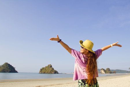 Happy young woman in sea with open hands and jump,Maya Bay, Koh Phi Phi Ley, Thailand. の写真素材