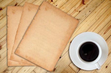 White cup of hot coffee and white sketch book on wood table の写真素材