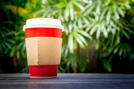 Paper cup of coffee in the gardenの写真素材