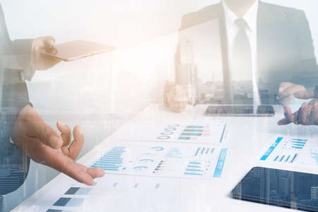 Double exposure partner business team making great business discussion in conference room at coworking office with skyscraper building blurred background,teamwork process and analyze business startup investment plans  concept,の写真素材