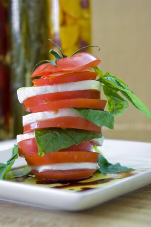 Caprese salad on a white plate with olive oilの写真素材