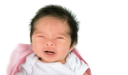 A crying newborn baby girl on a white backgroundの写真素材