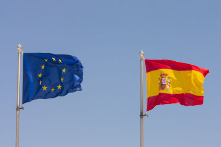 European Union and Spain Flags on blue sky