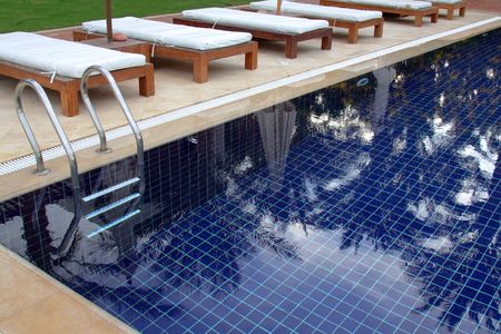 Fragment of swimming pool with reflection palm treesの写真素材