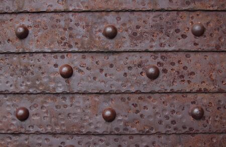 Fragment of a metal shod door with round rivetsの写真素材