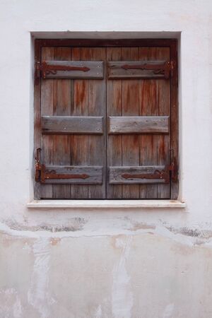 The closed old shutters against a white wallの写真素材