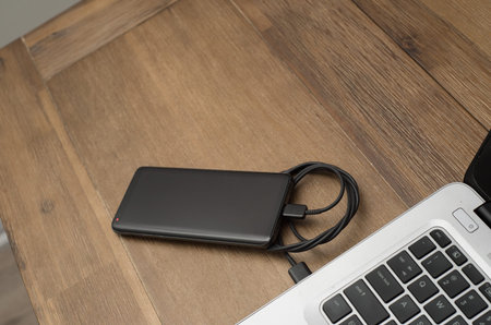 cellphone being charged from a laptop as a source of power