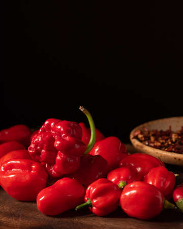 Assorted hot chilli pepper and crushed peppers on wooden surface. Ideal for food recipe or restaurant menuの写真素材