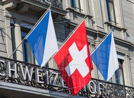 Zurich Switzerland  3 June 2015: flags of Zurich and Switzerland on the Schweizerhof hotel building facade.のeditorial素材