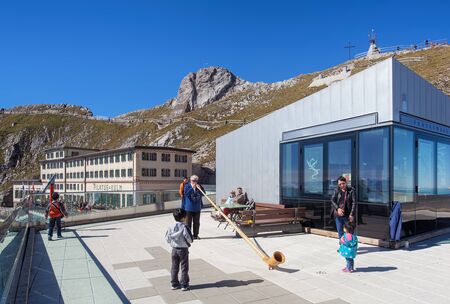 Mt. Pilatus, Switzerland - 23 September, 2014: tourists watching a person playing the alphorn. Alphorn or alpenhorn or alpine horn is a wind instrument, consisting of a wooden natural horn of conical bore, having a wooden cup-shaped mouthpiece, used by moのeditorial素材