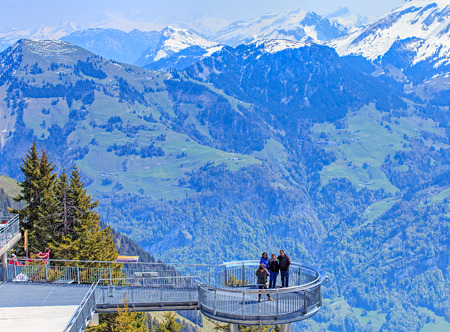 Mt. Stanserhorn, Switzerland - 7 May, 2016: view on the Alps with people posing for a photographer in the foreground. Stanserhorn is a mountain in Switzerland, located in the canton of Nidwalden near to the border with Obwalden, with the peak at 1,898 metのeditorial素材
