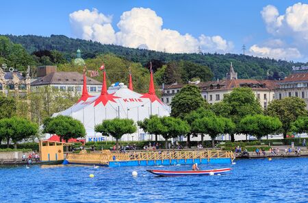 Zurich, Switzerland - 26 May, 2016: people on Lake Zurich with the tent of Circus Knie temporarily installed on Sechselautenplatz square in the background. Circus Knie is the largest circus of Switzerland, based in Rapperswil, founded in 1803 by the Knie のeditorial素材