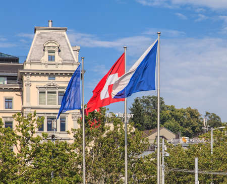 Zurich, Switzerland - 2 August, 2014: flags of Zurich and Switzerland on the Quaibruecke bridge, signs of Tages Anzeiger and Swiss Casinos in the background. Zurich is the largest city in Switzerland and the capital of the Swiss canton of Zurich.のeditorial素材