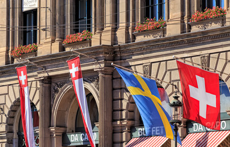 Zurich, Switzerland - 20 July, 2016: fags on the facade of the Zurich Main railway station building. Zurich Main railway station building was designed by architect Jakob Friedrich Wanner and opened in 1871.のeditorial素材